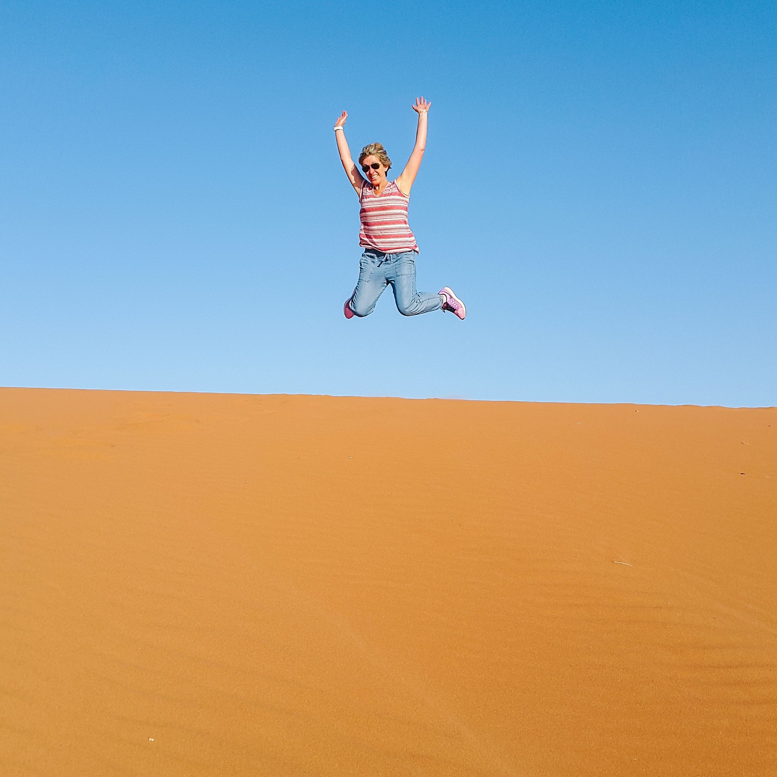 Turista fa una foto in salto nel deserto, tour in Giordania "Girolibero"